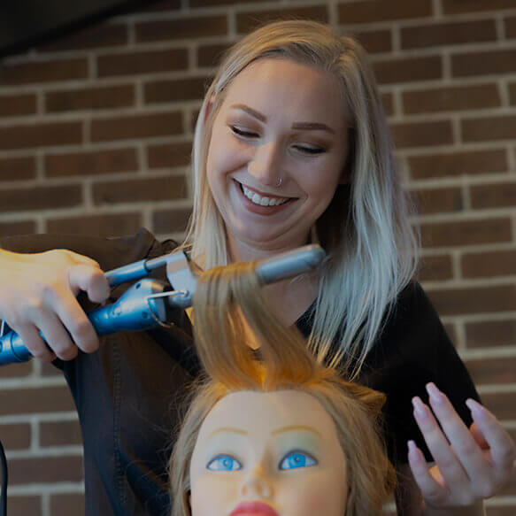 instructor showing student hair curling technique